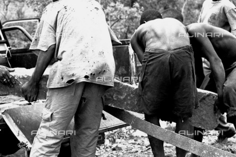 APN-F-027141-0000 - Guruwe  Zimbabwe  2004. A piece of Springstone to be used for sculture  is hauled onto a truck. Mining  labourers  poverty  stone  rock.Athol Rheeder/South. - AfriLife / Africamediaonline/Archivi Alinari, Firenze