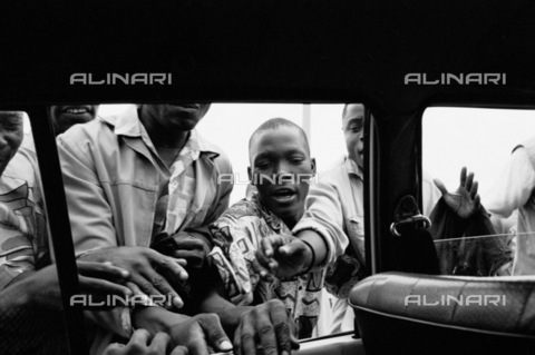 APN-F-028639-0000 - Maputo  Mozambique  2005. People who have helped to push this taxi  which got stuck in a market in Maputo  ask for payment for their services. Taxi  market.Athol Rheeder/South - AfriLife / Africamediaonline/Alinari Archives, Florence
