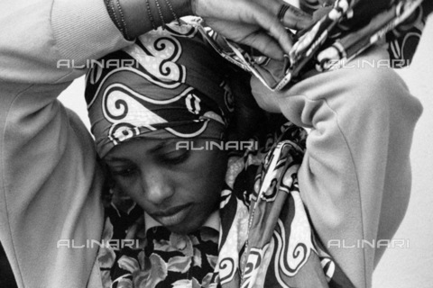 APN-F-031396-0000 - Rwanda  Kigali  2004. Rwandan woman adjusting her headdress. African  woman  black  beauty.Athol Rheeder/South - AfriLife / Africamediaonline/Alinari Archives, Florence