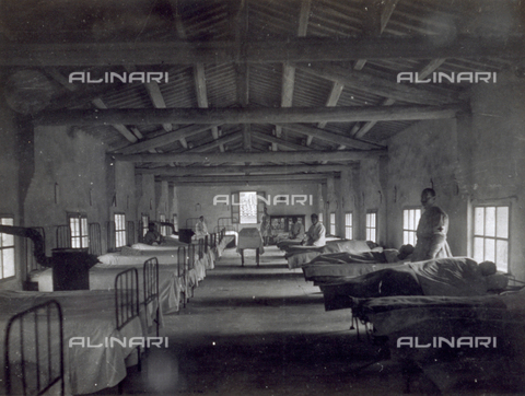 AVQ-A-000006-0008 - Main room of an infirmary in Noventa Vicentina. The large room, with an open timber roof, contains two rows of beds. A few patients and two red cross nurses are visible - Date of photography: 1918-1919 - Alinari Archives, Florence