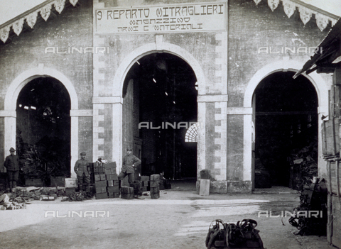 AVQ-A-000006-0009 - The entrance to one of the storerooms of the weapons and materials of the 9° Machine-Gun Division near Noventa Vicentina. In the area in front numerous packages and three soldiers - Date of photography: 1918-1919 - Alinari Archives, Florence