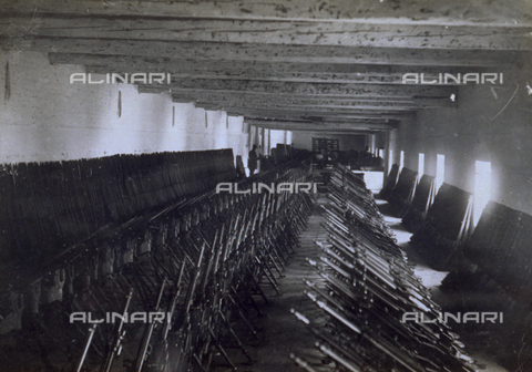 AVQ-A-000006-0015 - View of the workshop of the 9° Machinegun Division near Noventa Vicentina. The machineguns are arranged in three rows at the center while guns are leaning against the wall - Date of photography: 1918-1919 - Alinari Archives, Florence