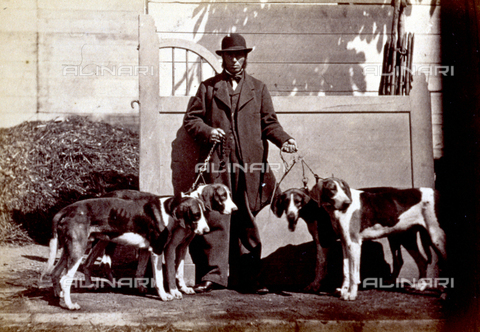AVQ-A-000477-0008 - Full-length portrait of a man. He is on a sidewalk and holds four hunting dogs on a leash - Date of photography: 1865 - Alinari Archives, Florence