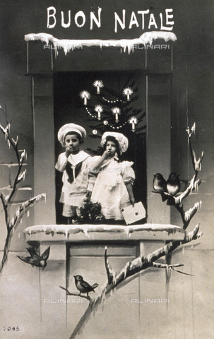 AVQ-A-002062-0052 - Cartolina postale natalizia. Al centro dell'immagine sono ritratti due bimbi in candidi abitini visibili attraverso una finestra disegnata - Data dello scatto: 1911 ca. - Archivi Alinari, Firenze