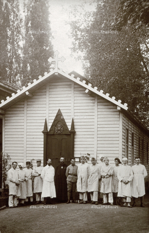 AVQ-A-002635-0204 - Portrait of a group of convalescent soldiers and a chaplain in cassock. They are posing in front of a small church built next to a military hospital - Date of photography: 1923 - Alinari Archives, Florence