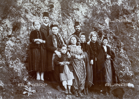 AVQ-A-003089-0026 - Full-length portrait of a group of Turkish men and women in traditional attire. They are posing outside, with a cliff wall in the background - Date of photography: 1890 ca. - Alinari Archives, Florence