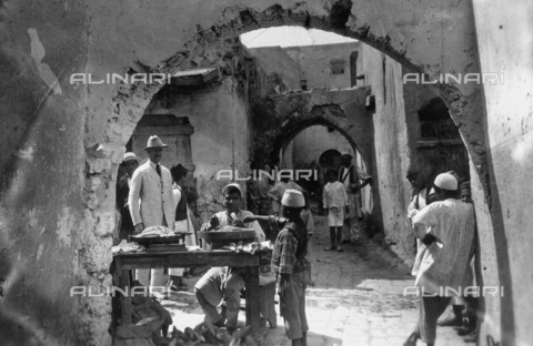 BPD-F-000714-0000 - A street in Tripoli with a seed vendor and a few tourists - Date of photography: 1930 ca. - Alinari Archives, Florence