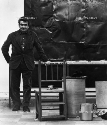 BPK-S-AA1001-1229 - L'artista Alberto Burri (1915-1995) ritratto accanto ad una sua opera - Data dello scatto: 1960-1670 - Charles Wilp / BPK/Archivi Alinari
