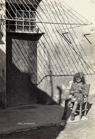 BVA-F-000354-0000 - A little girl making a small bunch of flowers, sitting in front of her door. Posstcard sent by the photographer to Vincenzo Balocchi - Date of photography: 1940 ca. - Alinari Archives, Florence