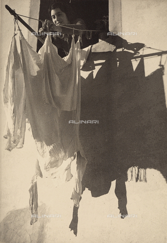 BVA-F-000541-0000 - A woman hanging out the washing. Postcard sent by the author to Vincenzo Balocchi - Date of photography: 1938 - Alinari Archives, Florence