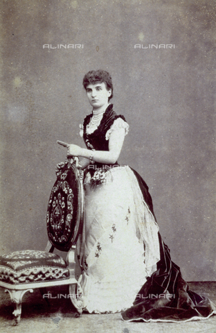 FBQ-F-002168-0000 - Full-length portrait of a lady, leaning against a chair, in magnificent evening dress with sprigs of artificial flowers. There are numerous string of pearls in the décolleté. It is probably Fiammetta Doria, member of the illustrious Genoese family - Date of photography: 1880 ca. - Alinari Archives, Florence