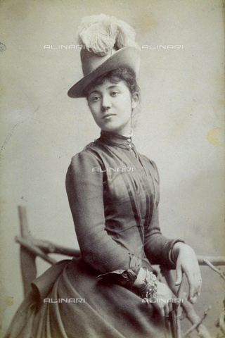 FBQ-F-002313-0000 - Three-quarter-length portrait of a young Lady in elegant day dress with a plumed hat. Her left arm is resting on a false railing. She is wearing numerous bracelets on her right wrist - Date of photography: 1887 - 1888 - Alinari Archives, Florence