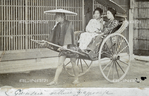 FBQ-S-001734-0025 - Rikshaw drawn by a man with a large hat. On board are two women in traditional costumes with parasol - Date of photography: 1870 ca. - Alinari Archives, Florence