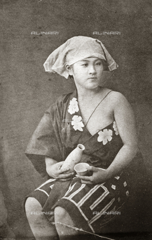 FBQ-S-001734-0028 - Portrait of a young Japanese man. He is seated and wearing ethnic dress, holding a small bowl and a ceramic bottle - Date of photography: 1870 ca. - Alinari Archives, Florence