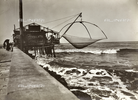 FVQ-F-008939-0000 - Cabin with fishing net on the waterfront of Viareggio; on the side of the advertising of Chocolate Torricelli - Date of photography: 1920 ca. - Alinari Archives, Florence