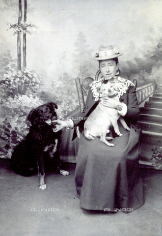 FVQ-F-055034-0000 - Studio portrait of a woman. She is sitting, with a dog in her arms and another dog is sitting by her side - Date of photography: 1890 - 1895 ca. - Alinari Archives, Florence