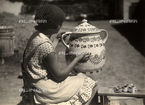 FVQ-F-138970-0000 - A Hungarian lady portrayed while she is painting an amphora with floral motifs; beside, on a small bench, the brushes and the glasses with the colours. - Date of photography: 1928 - 1935 - Alinari Archives, Florence