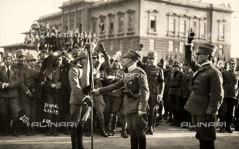FVQ-F-183570-0000 - Gabriele D'Annunzio gives a flag to a soldier, as a sign of greeting. The photograph was taken during the occupation of Fiume by part of his Italian legionary troops - Date of photography: 04/12/1919 - Alinari Archives, Florence