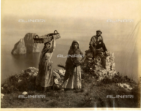 GBB-F-004338-0000 - 1885 ca, Isle of CAPRI, Napoli, ITALY : Women and a man, in background the celebrated FARAGLIONI. - © ARCHIVIO GBB / Archivi Alinari
