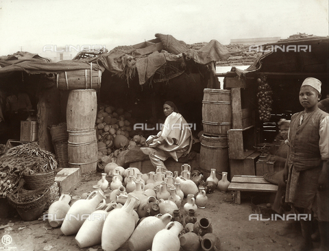 GLQ-F-002470-0000 - The Arab market: in the foreground there are some clay urns and pots, wooden barrels and vegetables. The image dates back to the Italian conquest of Libya, just after the Italian - Turkish war of 1911-1912 - Date of photography: 1911-1912 - Alinari Archives, Florence