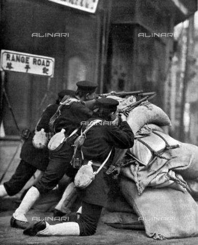 IIB-S-093210-0303 - Japanese sailors, from behind the protection of a barricade, shoot toward a Shanghai railway station - Date of photography: 02/1932 - Alinari Archives, Florence