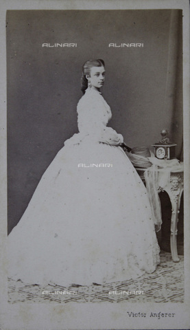 IMA-F-644113-0000 - Lady in white dress. On the atelier table a clock, full figure - Date of photography: 1867 - Victor Angerer / Austrian Archives / brandstaetter images /Alinari Archives