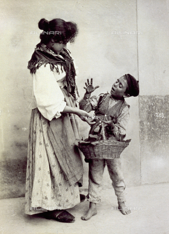 MFC-A-004650-0005 - Young woman arguing with a child who is selling fruit. They are shown in folk dress - Date of photography: 1890 ca. - Alinari Archives, Florence