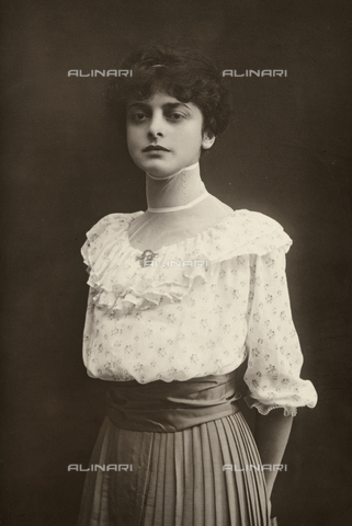 MFC-F-001256-0000 - Three-quarter-length portrait of young woman standing, with her hands behind her back. She is wearing a pleated skirt and a ruffled blouse - Date of photography: 08/1917 - Alinari Archives, Florence