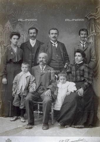 MFC-F-001845-0000 - Group portrait, probably a family, composed of men, women and two children. Behind them, a painted backdrop - Date of photography: 1900 ca. - Alinari Archives, Florence