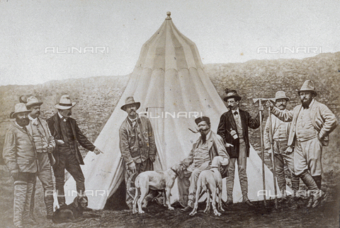 MFC-F-004111-0000 - Portrait of King Victor Emmanuel II with Marquis Lovera and other men in a hunt. Victor Emmanuel is seated and petting the dogs before his tent - Date of photography: 1875-1880 ca. - Alinari Archives, Florence