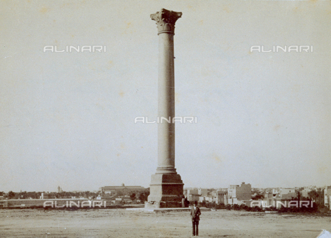 MFC-S-001133-0013 - Pompey's pillar in Alexandria in Egypt. In the background panorama of the city. A few passersby add life to the scene - Date of photography: 1880-1890 - Alinari Archives, Florence