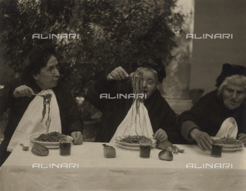 MFC-S-004217-0002 - Gruppo di anziane sedute a tavola intente a mangiare un piatto di spaghetti - Data dello scatto: 1920-1930 ca. - Archivi Alinari, Firenze