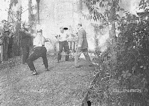 PAS-F-000445-0000 - Due uomini duellano di spada in un parco, con testimoni e pubblico. - Data dello scatto: 1921 - Istituto Luce/Gestione Archivi Alinari, Firenze