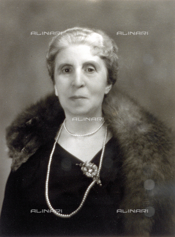 PDC-F-000599-0000 - Half-length portrait of a lady in a dark dress wearing a broach . A long pearl necklace and a fur stole complete ensemble. - Date of photography: 1920-1930 - Alinari Archives, Florence
