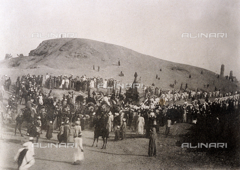 PDC-F-000695-0000 - A procession of people on foot and on richly caparisoned horses accompany an elaborate litter in the sandy desert. In the background a dune - Date of photography: 1880 -1900 ca. - Alinari Archives, Florence