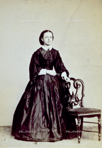 PDC-F-001510-0000 - Full-length portrait of a young lady in elegant day dress. She is standing next to a chair - Date of photography: 1860 -1870 ca. - Alinari Archives, Florence
