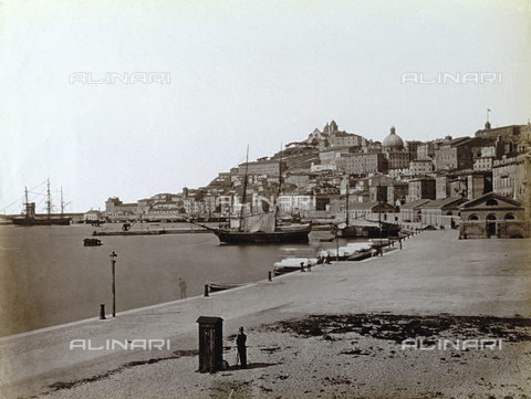 PDC-F-002661-0000 - Panorama of Ancona: in the foreground, the promenade with the wharf and some sail-boats moored; in the background, a part of the city with the Church of San Ciriaco, which stands on the top of a hill. On the promenade, a sentry stands guard, in front of a sentry box - Date of photography: 1875 ca. - Alinari Archives, Florence