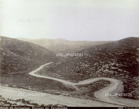 PDC-S-000752-0003 - View of a hilly desert area on the road for Jerusalm, with the river Terehinthe. A dirt road winds through the slopes. Two people can be made out in the distance - Date of photography: 1880-1900 - Alinari Archives, Florence