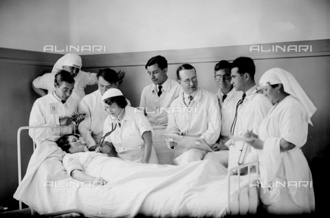 RVA-S-000310-0015 - Doctor auscultates the heart of a patient in the Broussais hospital in Paris - Date of photography: 1935 - Jacques Boyer / Roger-Viollet/Alinari