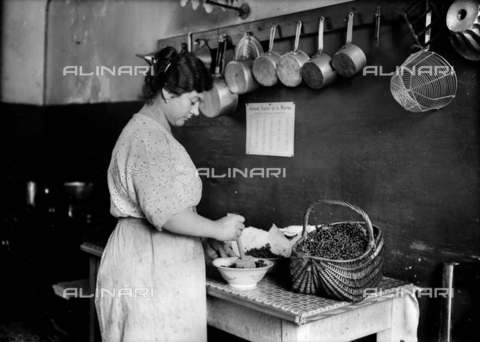 RVA-S-005874-0012 - Housewife grinding redcurrant in a mortar to make jelly. France, 1925. - Jacques Boyer / Roger-Viollet/Alinari
