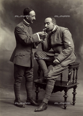 TCA-F-01479V-0000 - Alfredo Trombetta and Michelangelo Benevento photographed in military uniform. The two men are lighting a cigarette. - Date of photography: 1917 - Alinari Archives, Florence