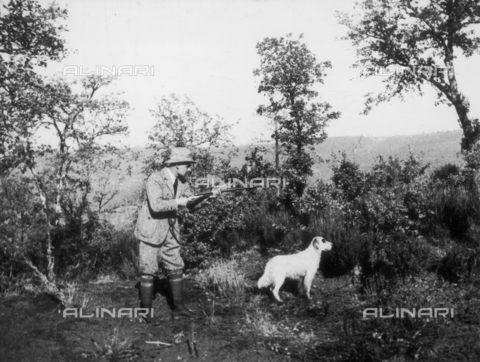 TCI-S-000292-AR10 - Pheasant hunt in the woods by the tall brush, hunter with dog - Date of photography: 1940 ca. - Touring Club Italiano/Alinari Archives Management