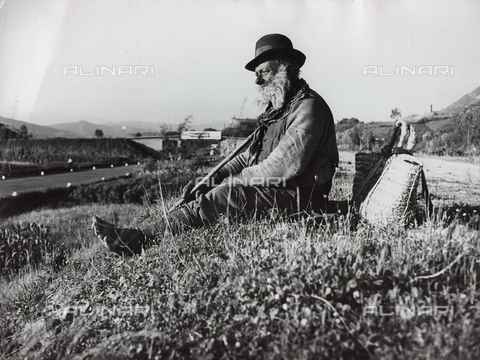 TCI-S-000451-AR09 - An elderly vagabond on a ridge above the Firenze-Mare freeway - Date of photography: 1930-1940 - Touring Club Italiano/Alinari Archives Management