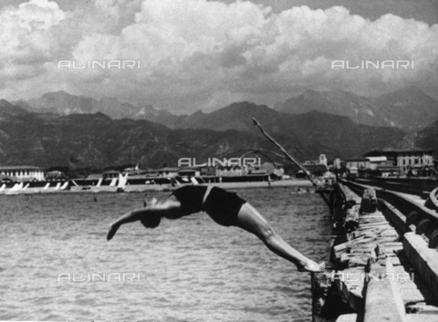 TCL-F-003987-0000 - Snapshot of a young woman in a spectacular dive backwards from the jetty of Forte dei Marmi, Versilia - Date of photography: 1930 ca. - Touring Club Italiano/Alinari Archives Management