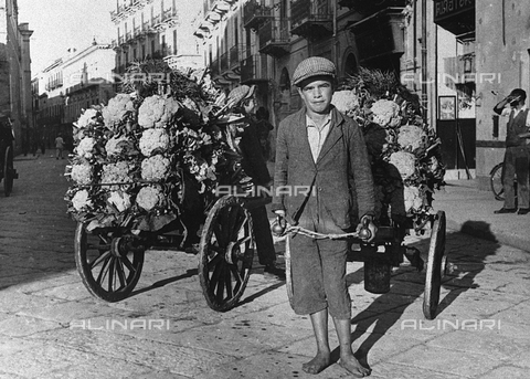 TCV-F-002731-0000 - Full-length portrait of an itinerant cabbage vender. He is posing along a city street pulling a cart full of vegetables - Date of photography: 1935 ca. - Touring Club Italiano/Alinari Archives Management