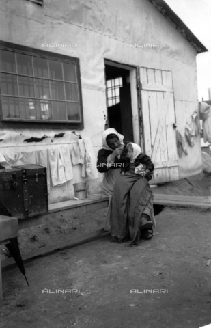 UAQ-S-001002-5005 - Campo di internamento di Katzenau, periferia di Linz, Austria: una donna nutre il suo bambino davanti alla baracca - Data dello scatto: 1915-1918 - Archivi Alinari, Firenze