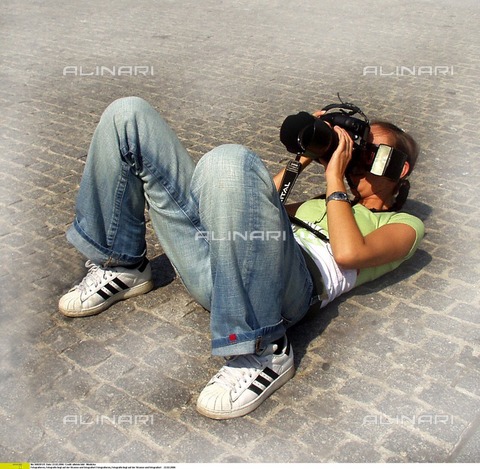 ULL-F-828125-0000 - A girl takes a picture lying on the ground - Date of photography: 22/02/2006 - Wodicka / Ullstein Bild / Alinari Archives