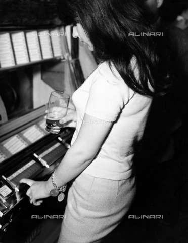 ULL-F-894464-0000 - A girl in front of the jukebox - Date of photography: 1964 - Langpeter / Ullstein Bild / Alinari Archives